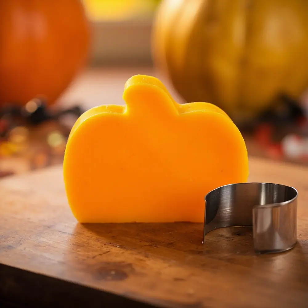 Fun with Food: Using Cookie Cutters for Pumpkin Shaped Cheese & Crackers 6 Image-6: A photo showing a perfectly cut-out cheese pumpkin sitting next to the cookie cutter, highlighting the clean edges.