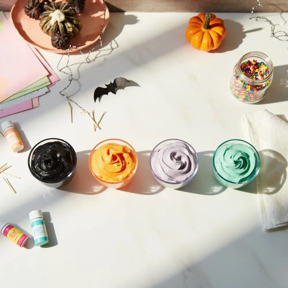 Step-by-Step DIY: Halloween Cake Toppers & Themed Cupcakes (Cricut & No-Cricut Options!) 5 White being black food bowls gel orange with of frosting p small coloring nearby bottles glass em one and is four green mint image 5 colored lavender