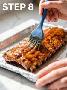Hand_brushing_sauce_on_ribs_202605252121_kaveeshmommy_ -