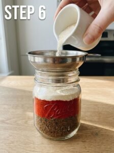 Woman_pouring_powder_into_jar_202605251656_kaveeshmommy_ -