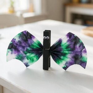 Tie-Dye Coffee Filter Clothespin Bat - Vibrant purple and green bleed-dyed coffee filter pinched into a black wooden clothespin with wiggle eyes