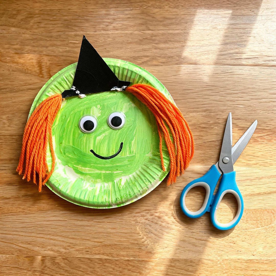 Paper Plate Little Witch - Green painted paper plate with pointed black paper hat and yarn hair