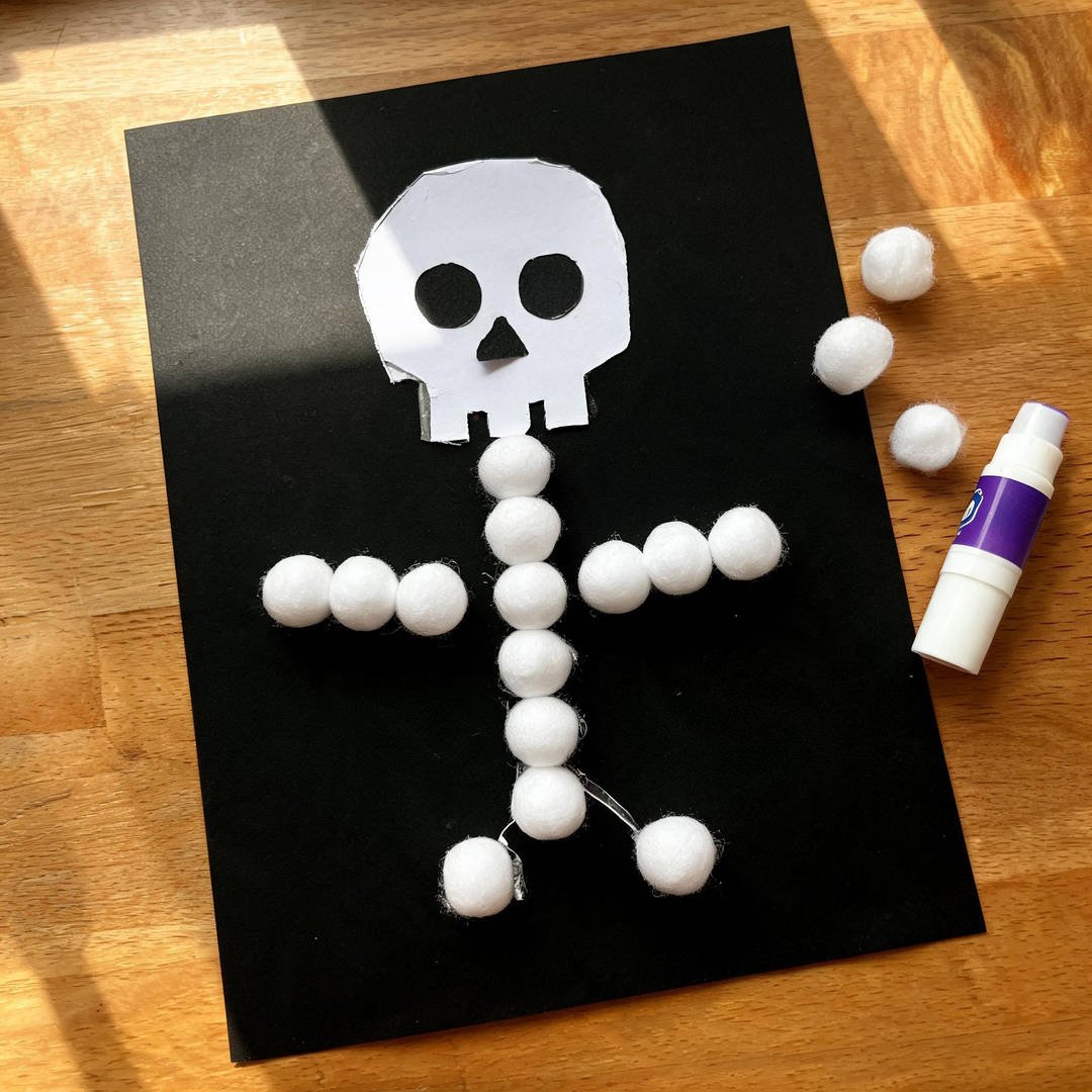 Cotton Ball Dancing Skeleton - Fluffy white cotton balls glued flat onto black cardstock in a skeleton shape