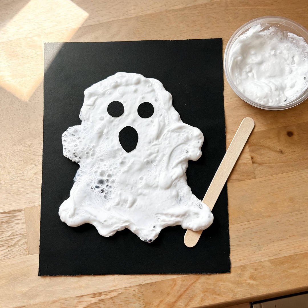Shaving Cream Puffy Paint Ghost - Thick white shaving cream and glue mixture spread into a ghost shape on black paper