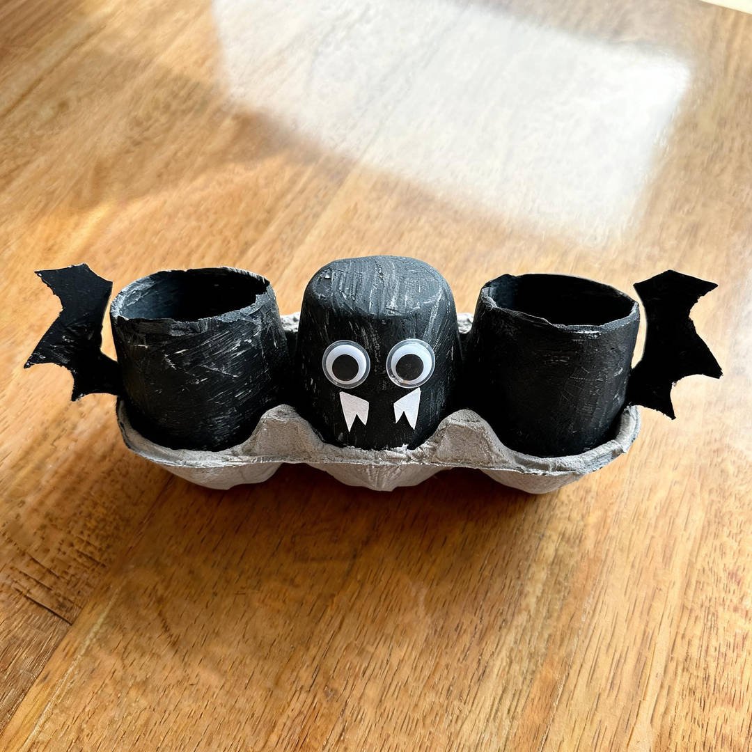 Egg Carton Hanging Bat - Three connected cardboard egg carton cups painted black with googly eyes