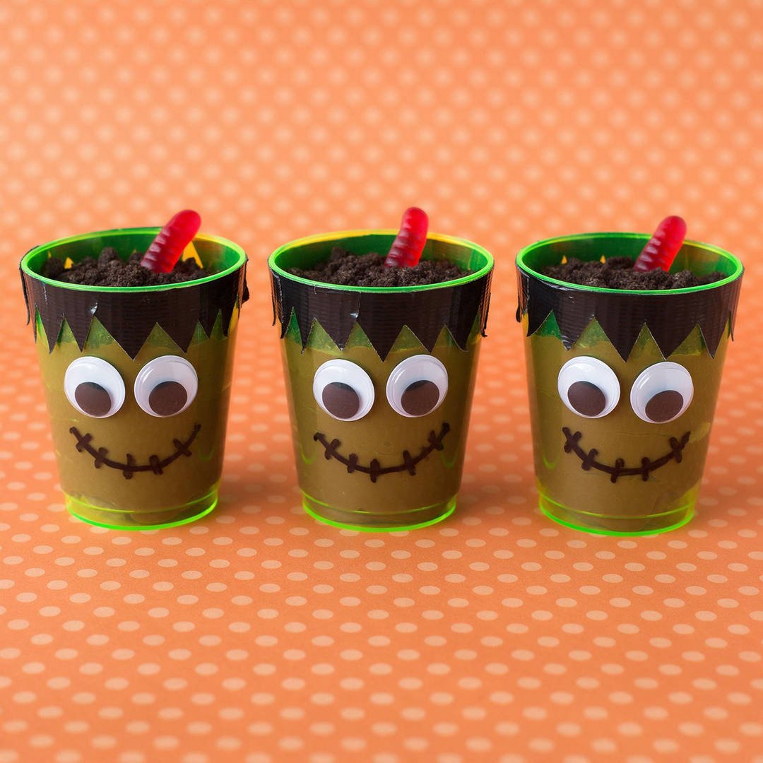 Plastic Tumbler Frankenstein Monster Cups - Green plastic tumblers decorated with black duct tape hair, googly eyes, and chocolate pudding